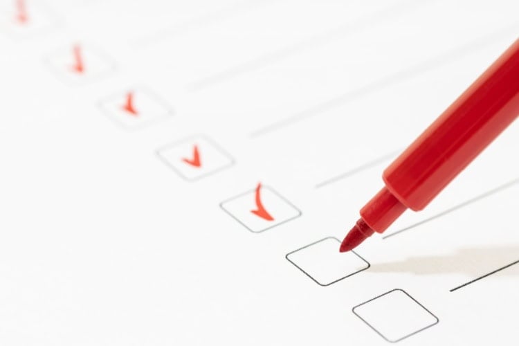 A checklist being marked by a red marker.